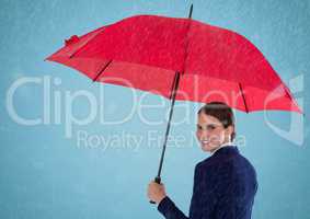 Business woman looking over shoulder with umbrella against blue background and rain