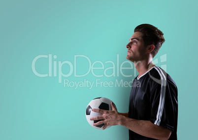 soccer player looking up with ball on hands. blue background