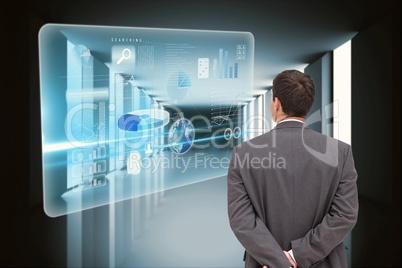 Business man watching graphics hands behind the back against graphics background