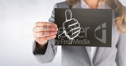 Business woman mid section with black card showing white thumbs up doodle against white wall