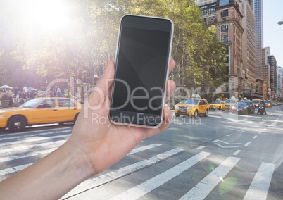 Hand with phone against street with flares