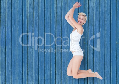 fitness woman jumping with blue wood background