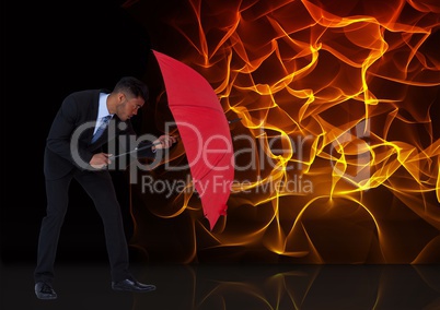 Digital composite image of businessman holding red umbrella against fire