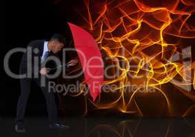 Digital composite image of businessman holding red umbrella against fire