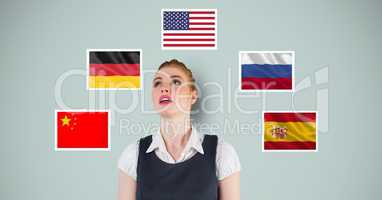 Businesswoman looking up while standing by various flags against blue background