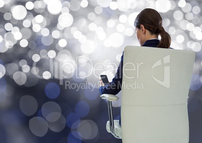 Businesswoman Back Sitting in Chair with  mobile phone and bokeh sparkling lights