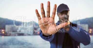 Security guard with walkie talkie and hand in front against blurry skyline