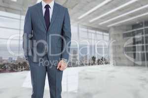 business man is holding on with a hand in the pockets against room background