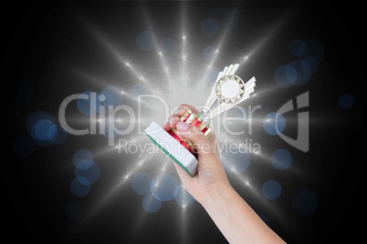 Hand holding a trophy against black background