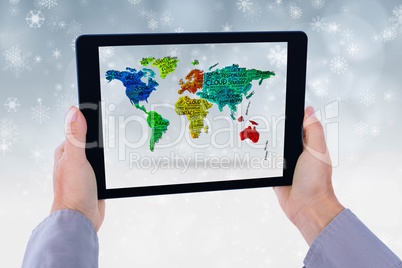 Model is showing world map from the tablet computer screen against snowflake background