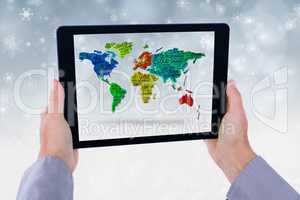 Model is showing world map from the tablet computer screen against snowflake background