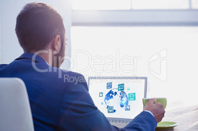 Businessman at desk with laptop and digital icons