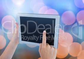 Hand touching tablet with sparkling light bokeh background