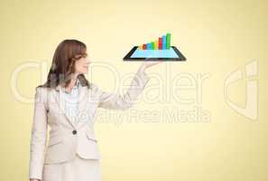 Business woman is holding a tablet computer projecting holograms against yellow background