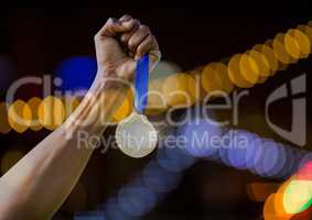 Hand holding medal win with sparkling light bokeh background