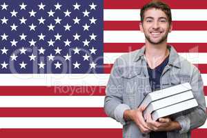 Student holding books in front of american flag