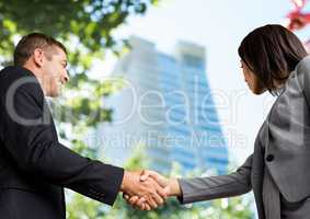 business man and woman handshake. Sky view. City in front of the building of the office