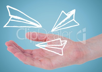 Hand with white paper airplane doodle against blue background