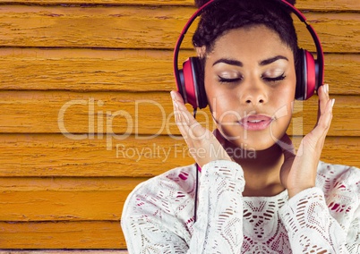 hipster woman listening music, with yellow wood background