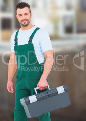 Construction Worker with tool box in front of construction site