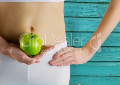 fitness woman. apple and belly with light blue wood background