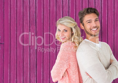 couple back with back, smiling with pink wood background