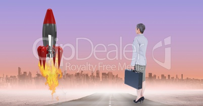 Digital composite image of businesswoman watching rocket launch against city
