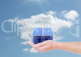 Digital composite image of solar panel house on hand against sky