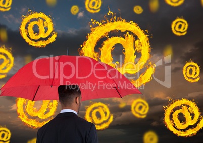 Digital composite image of businessman holding red umbrella standing amidst burning at symbol