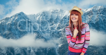 Portrait of smiling hipster standing against snowcapped mountains