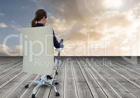 Businesswoman Back Sitting in Chair with mobile phone on wood with cloudy sky