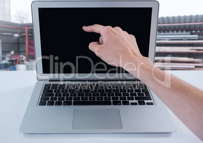 Businessman touching laptop with construction site background