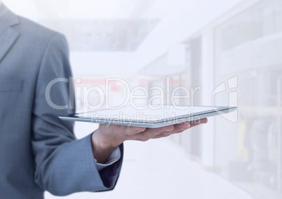 Businessman holding tablet in bright shopping mall