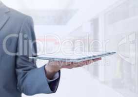 Businessman holding tablet in bright shopping mall