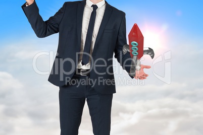 Businessman is holding a rocket taking off from his hand against sky background