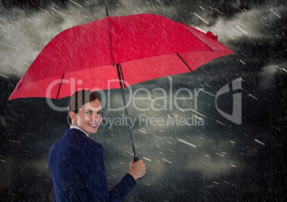 Business woman looking over shoulder with umbrella against rainy sky