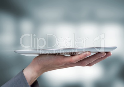 Hand holding tablet with blur background