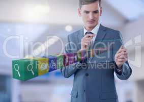 Businessman holding glass screen with apps  in large bright space