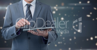 Businessman holding tablet with star spangled background