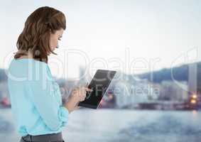 Businesswoman holding tablet with distant city background