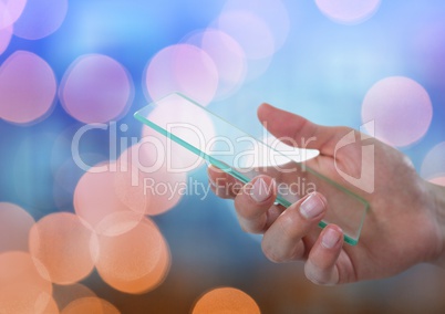 Hand holding glass device with sparkling light bokeh background