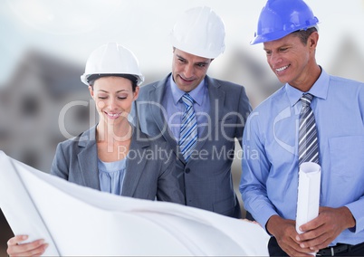 Architects with blueprints on building site