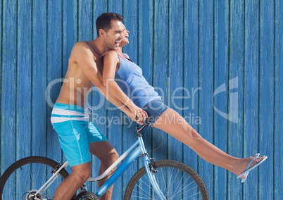 couple in bicycle with blue wood background