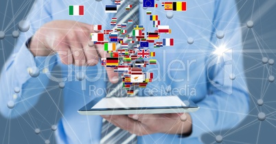 Digital composite image of businessman holding digital tablet with flags and connecting dots