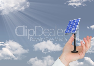 Digital image of hand holding solar panel on sky
