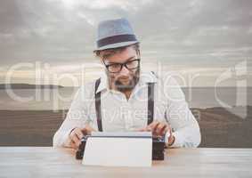 Hipster man  on typewriter by sea hill landscape