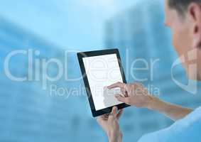 Doctor holding tablet with tall blue buildings