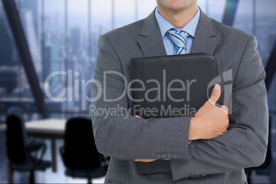 business man holding a notebook against office background