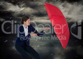 Business woman with umbrella blocking rain against storm clouds