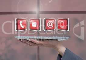 Businesswoman holding tablet with apps icons by window